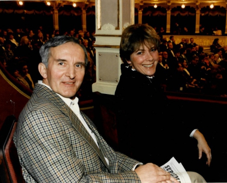 Na zdjęciu kobieta i mężczyzna siedzą w parterowej loży widowni Dużej Sceny Teatru im. Juliusza Słowackiego w Krakowie. Uśmiechają się. Za nimi parter widowni, na której wszystkie miejsca są zajęte.