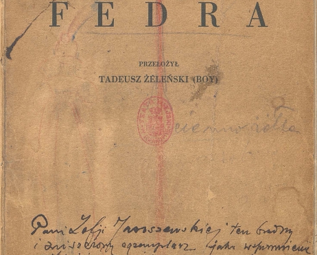 Zdjęcie karty tytułowej egzemplarza reżyserskiego scenariusza do spektaklu „Fedra” na podstawie tekstu Jeana Racine’a w przekładzie Tadeusza Boya Żeleńskiego. To pożółkły ze starości maszynopis z ręcznie dopisanymi notatkami wykonanymi czarnym tuszem lub atramentem. Na środku karty odbita jest czerwona, owalna pieczątka biblioteczna. W dolnej części karty odręcznie napisana jest dedykacja napisana przez reżysera.