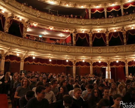 Zdjęcie przedstawia widownie Dużej Sceny oraz lożę cesarską. Osoby siedzące patrzą na wprost na scenę. Na widowni młodzi ludzie około 17 lat. Tłem są loże pierwszego i drugiego piętra.