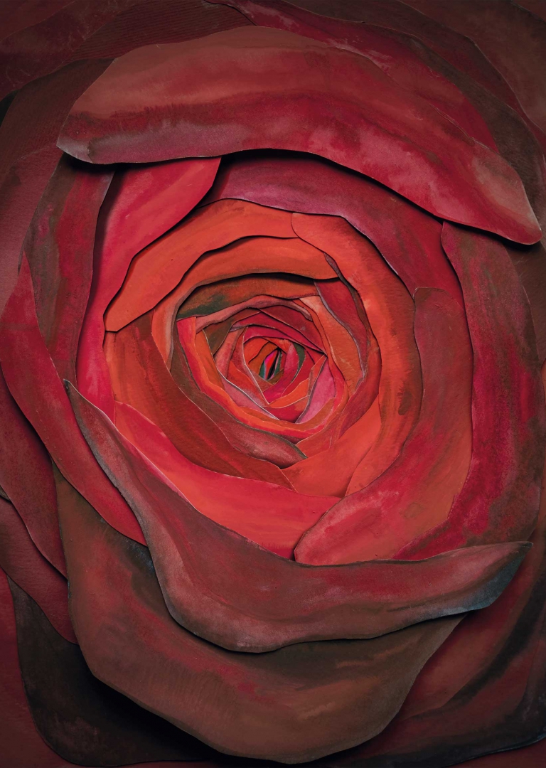 Plakat do spektaklu „Imię róży”. Ilustracja rozwiniętego, czerwonego kwiatu róży. Narysowany został od góry. Płatki do wewnątrz stają się coraz jaśniejsze i mniejsze tworząc głębię. Całość przypomina waginę.
