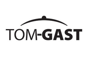 Czarny napis TOM-Gast, drukowane litery, pomiędzy literami M i G jest myślnik. Słowo Tom pogrubionym fontem, Gast niepogrubiony. nad napisem czarny łuk w kształcie tęczy. Pośrodku łuku czarna kropka.